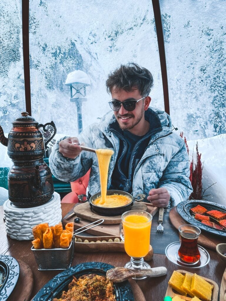 a fashionable man enjoys fondue after skiing