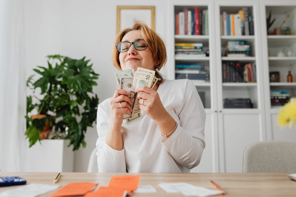 a woman looks happy as she holds money