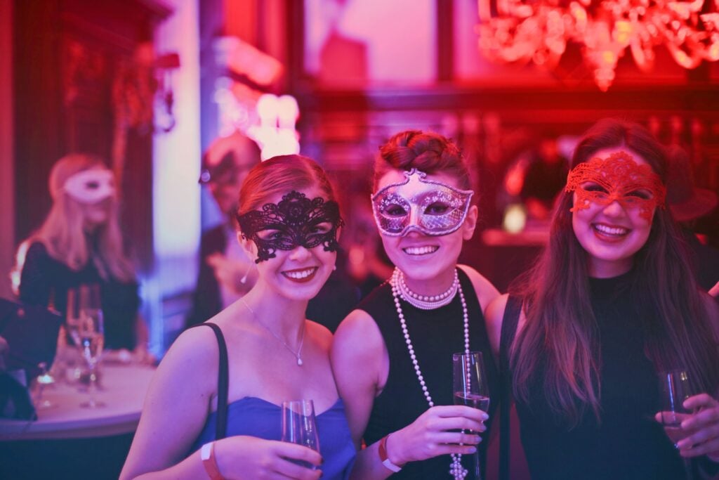 guests in masquerade masks enjoy a party