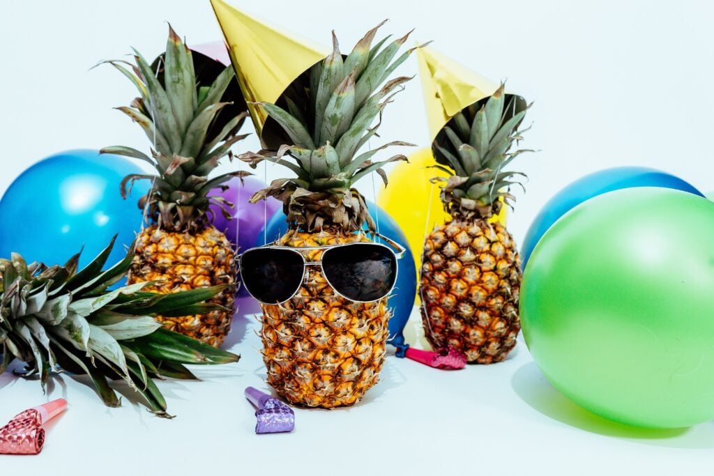 a pineapple wearing sunglasses and other party memorabilia