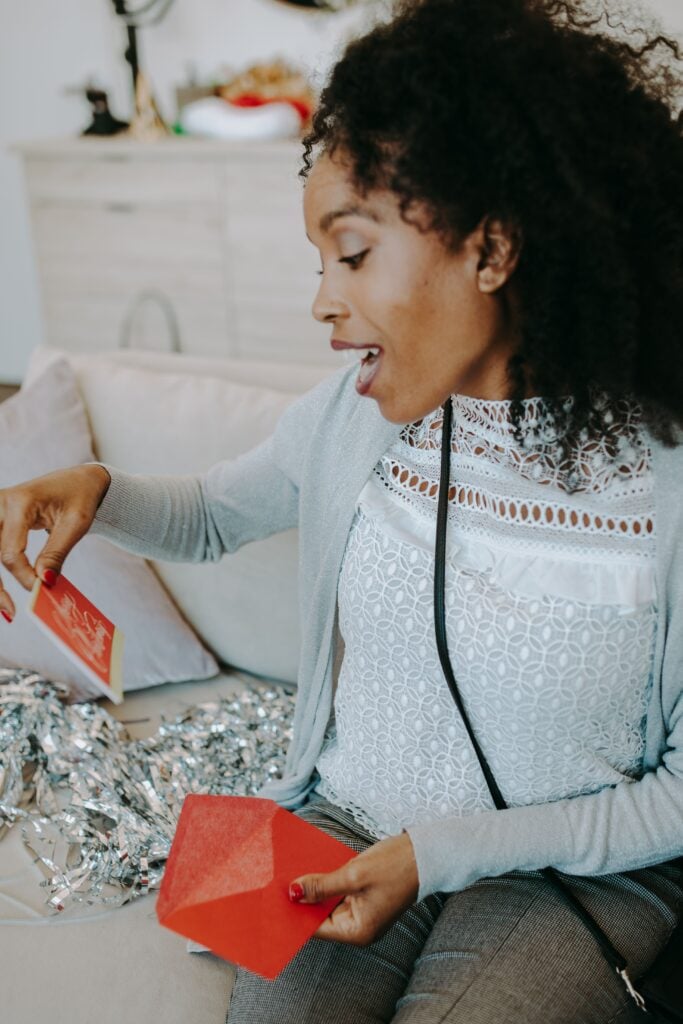 a woman excitedly recieves a christmas card
