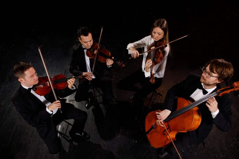 string quartet playing against black stage