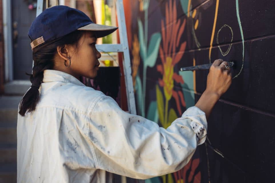 woman live painting mural during corporate event