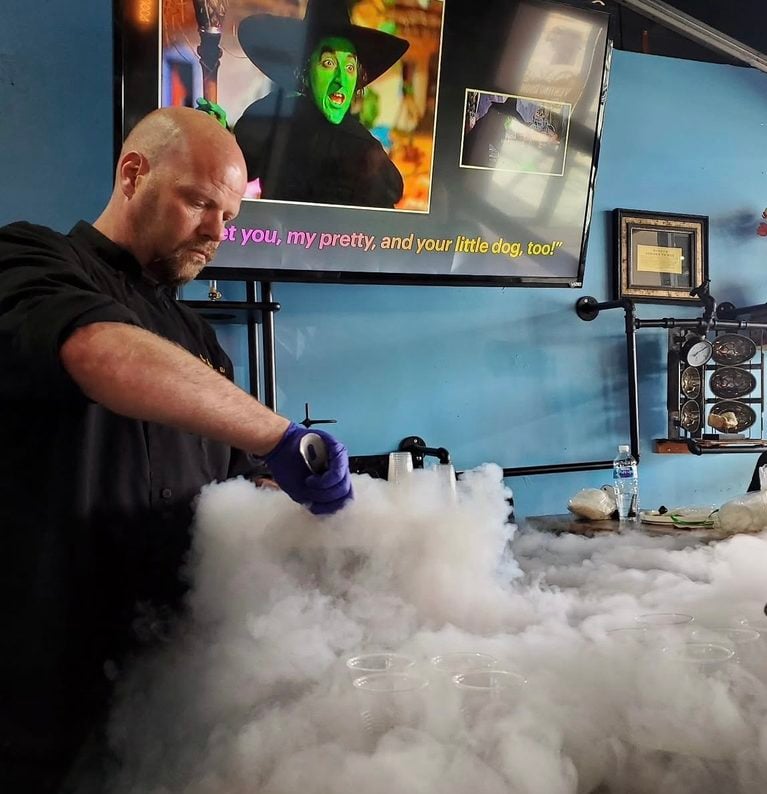 a man concocts of a sugary mix at his dessert parlor