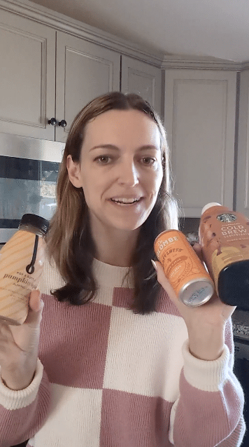 noelle holding up three different pumpkin spice lattes