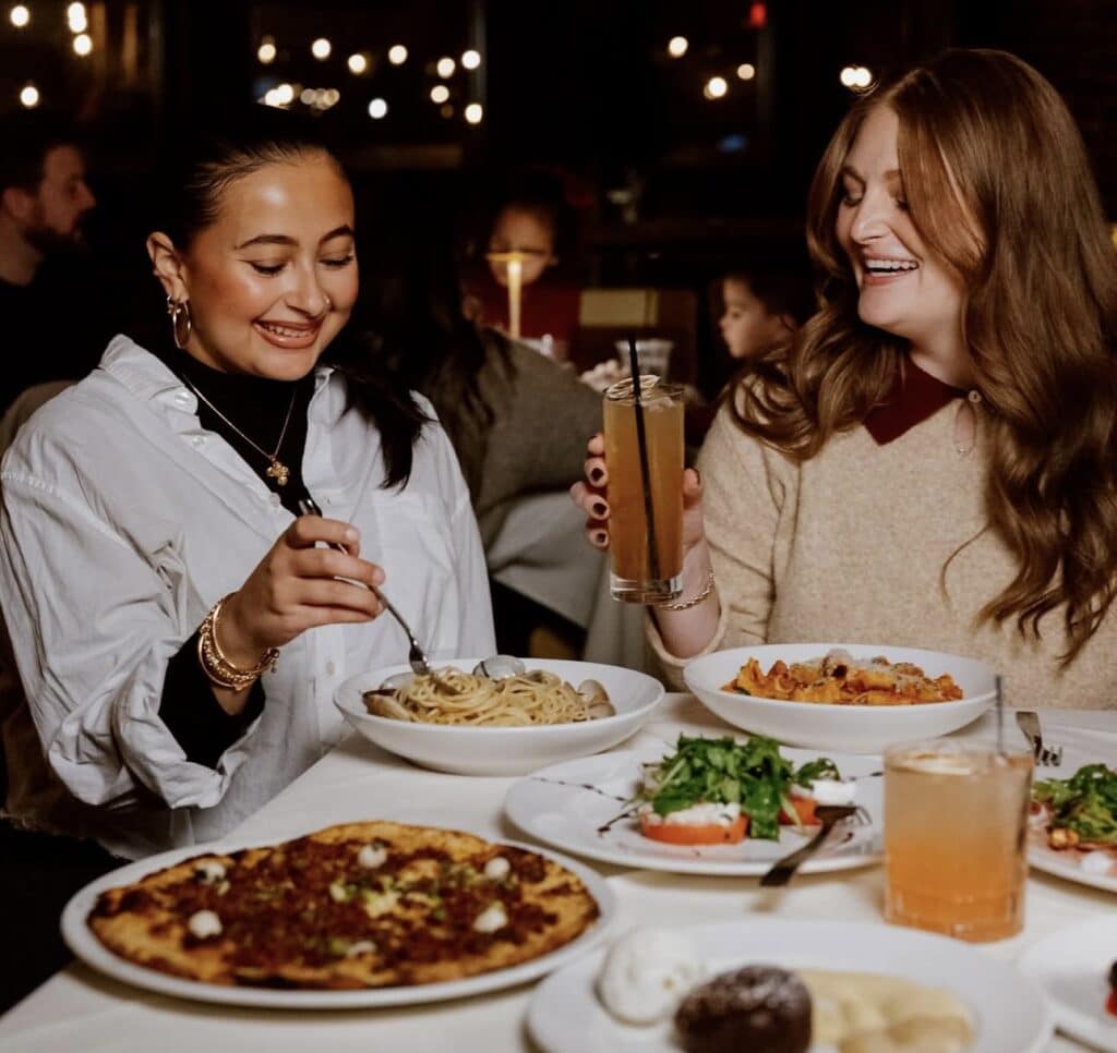 Friends enjoy a delicious Italian meal at Scampo in Boston
