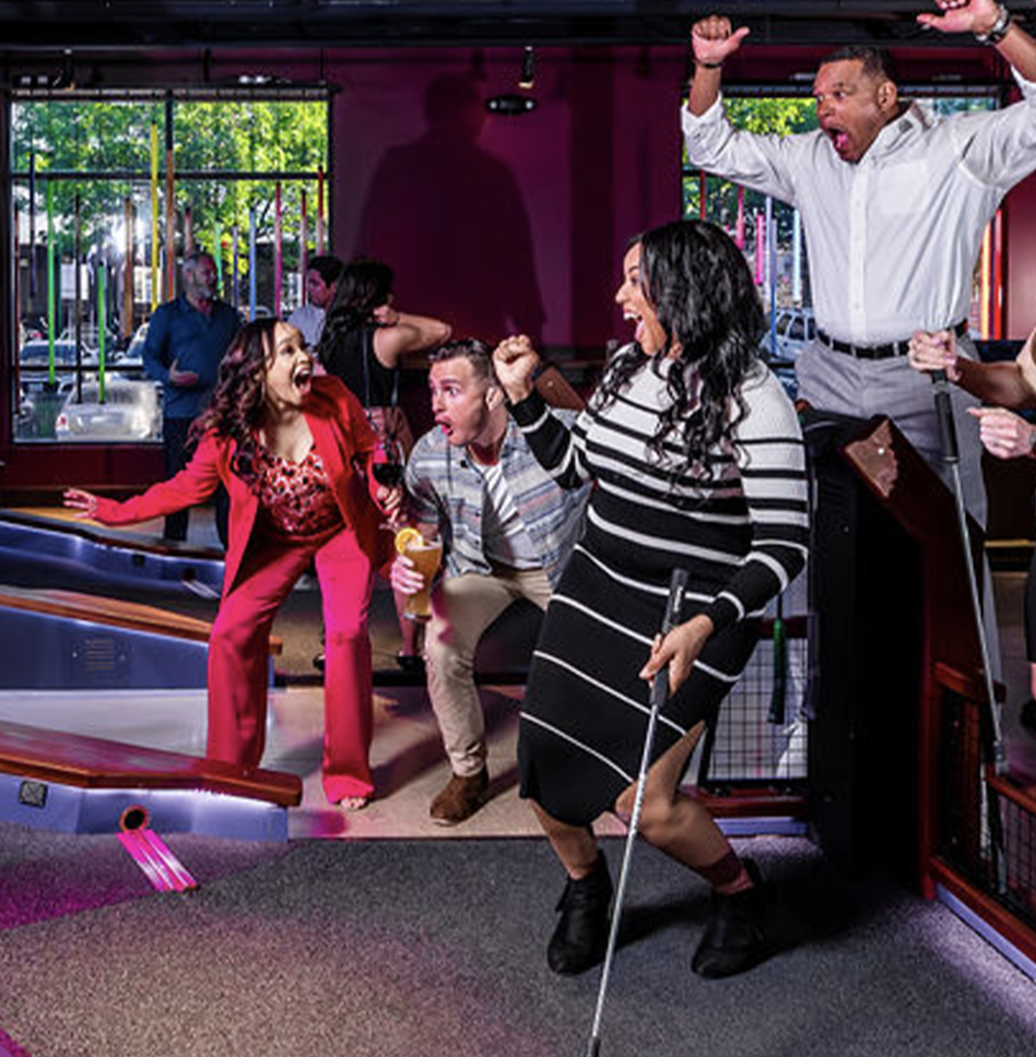 Coworkers cheer each other on at Puttshack in Denver