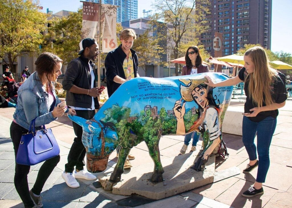 Team members gather around an iconic landmark in Denver on a DIY scavenger hunt