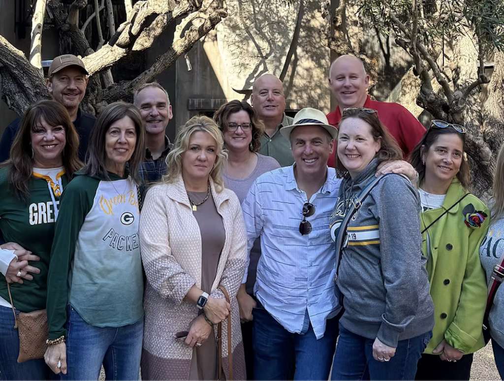 A team poses outside a vineyard on a Gourmet Food and Wine Tour