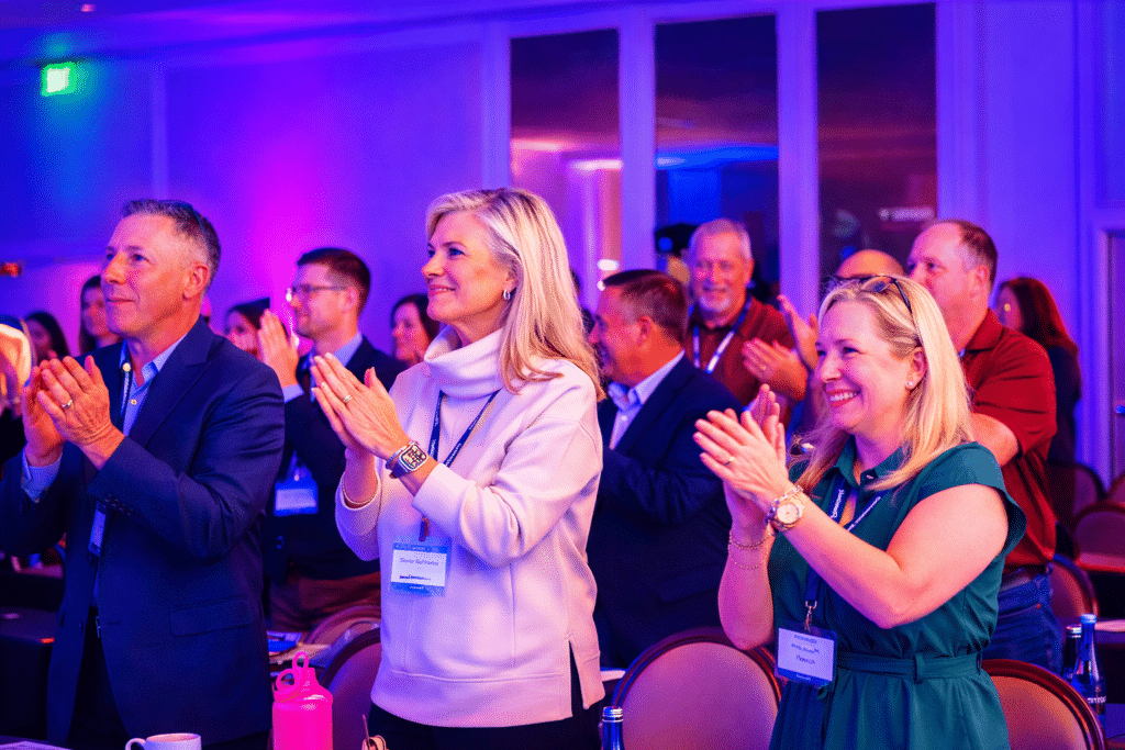Guests at a Hunter Events corporate event stand and applaud a speaker