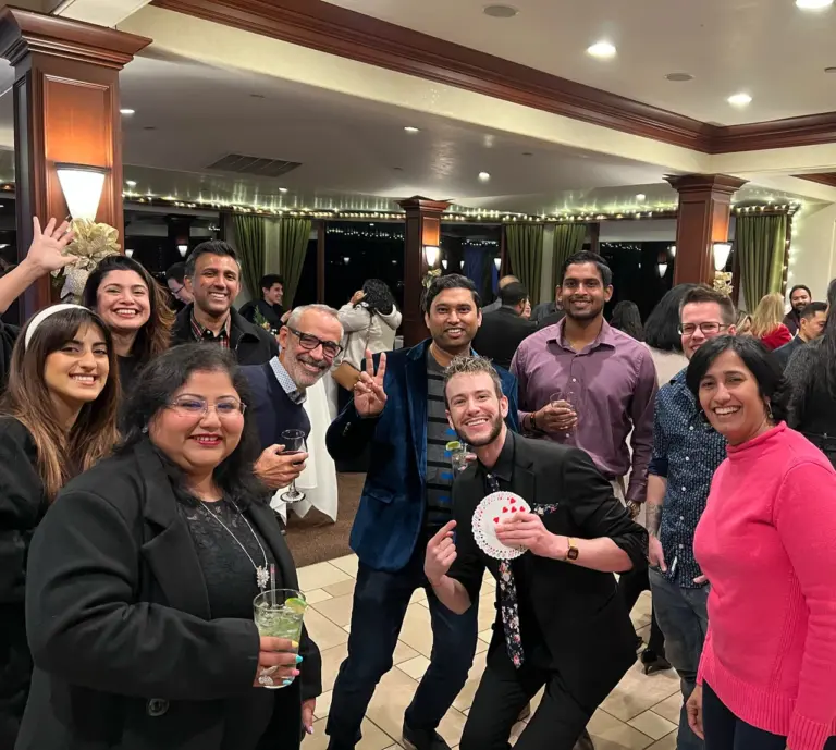 Spencer Grey poses with impressed guests after performing a card trick at a corporate event