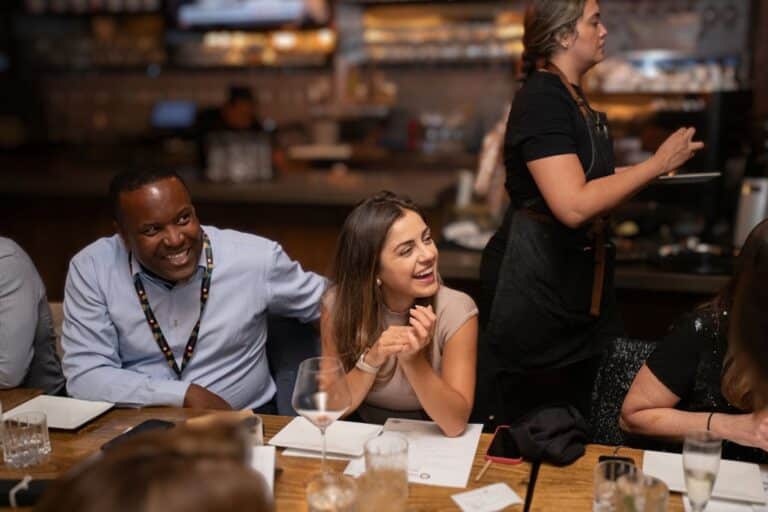 two guests smiling at table during client engagement dinner nyc