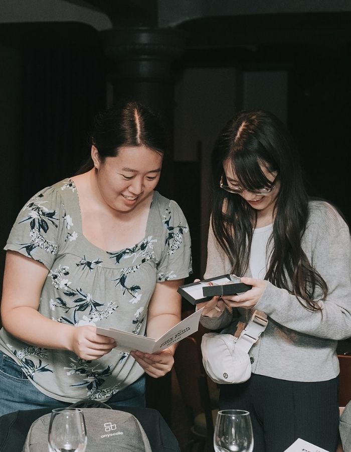two women looking at menu during event