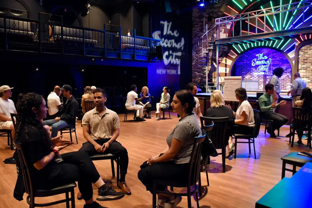A team sits together playong improv games with Second City Chicago