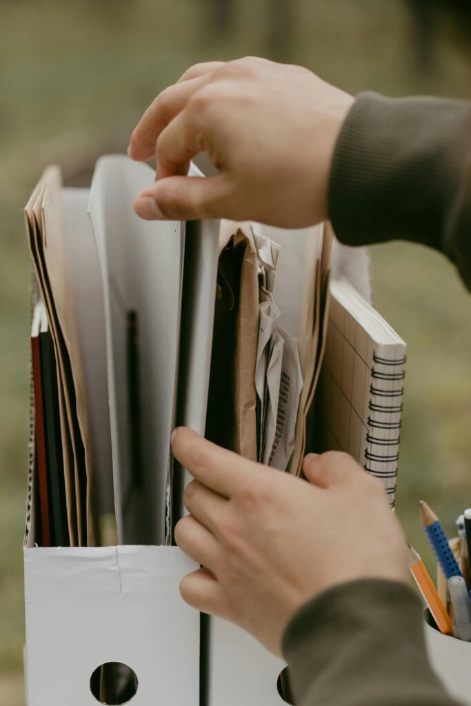 A hand reaches for materials to construct a paper tower