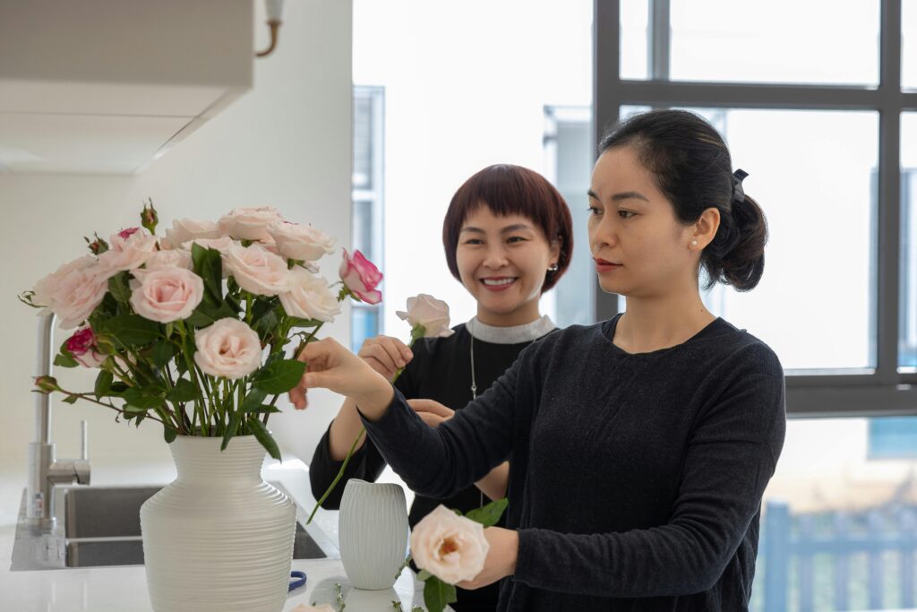 Two women arrange flowers together