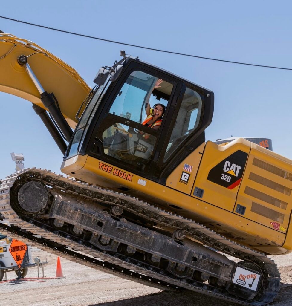 Team members drive bulldozers at Dig This in Vegas