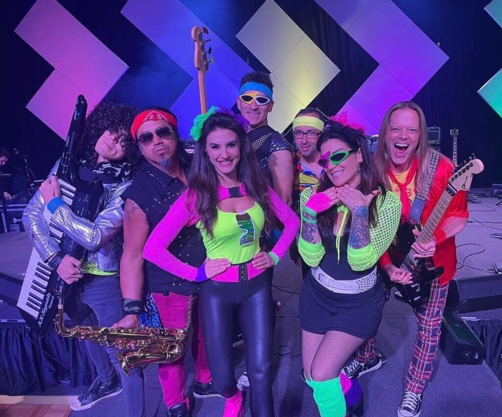 Coworkers pose in neon outfits at Song Division Vegas