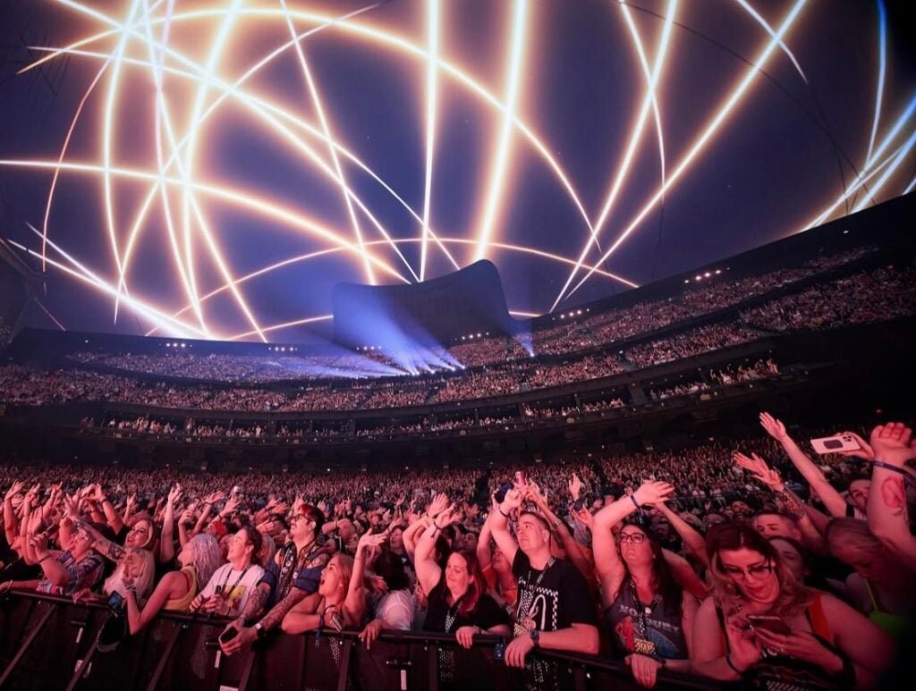 Crowds dance at the Sphere in Vegas under a ceiling light show