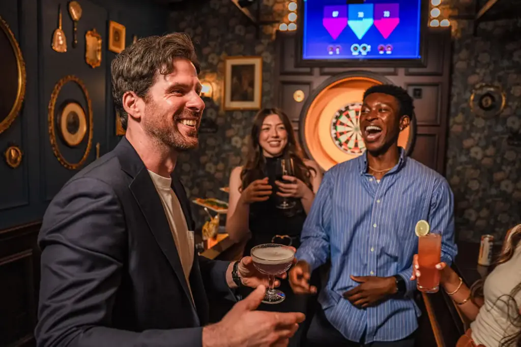 Coworkers laugh together by dart boards at Fight Club Darts in Vegas