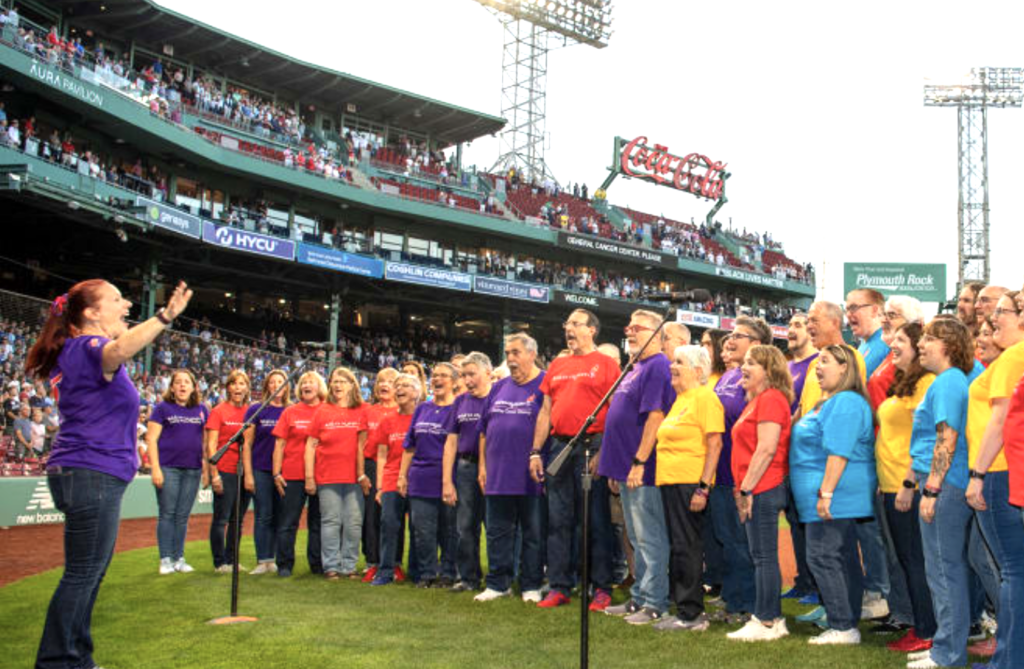 A team takes to the field to sing the national anthem at a Red Sox Game