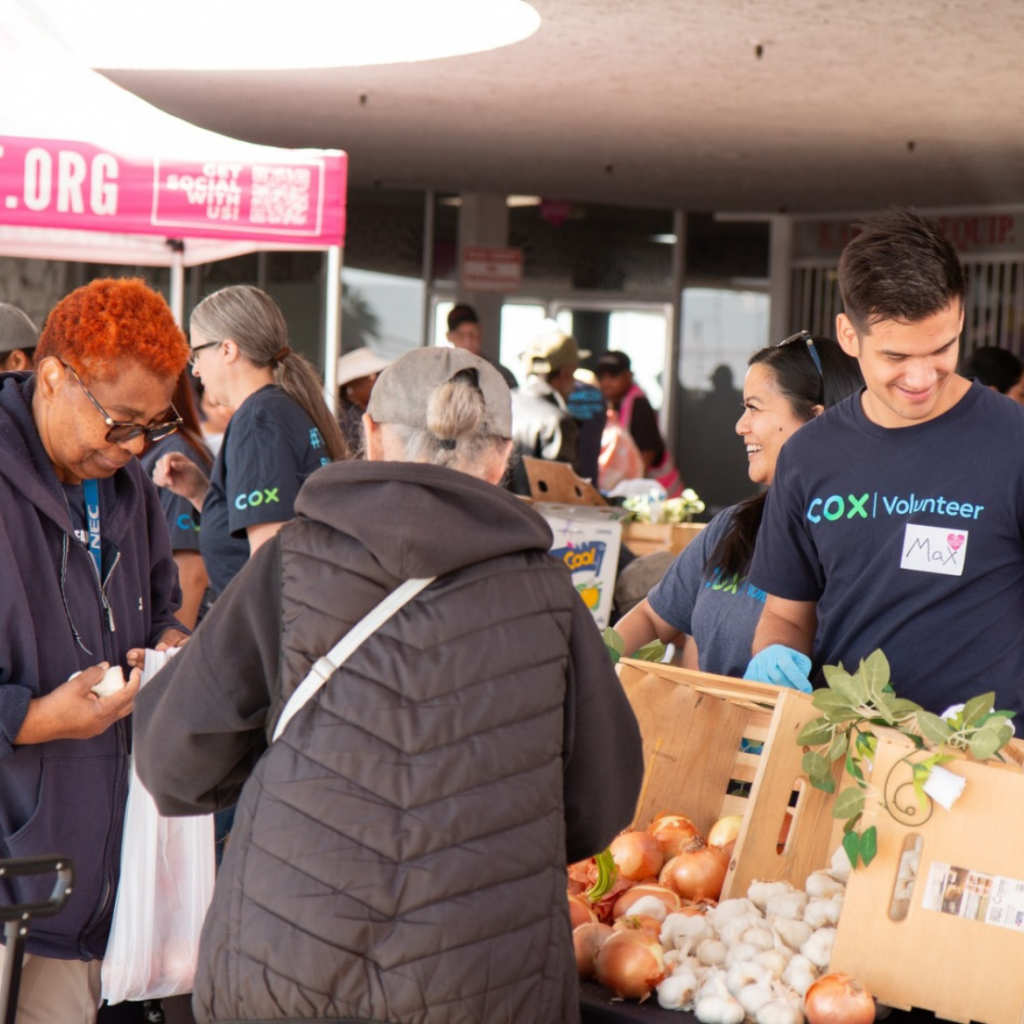 Team members help give out food at the Just One Project