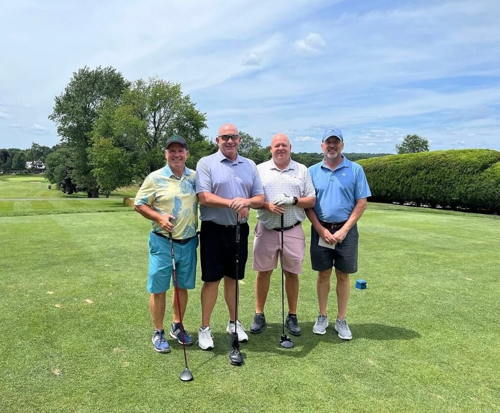 Freinds smile on the greens of the Bellevue Golf Course