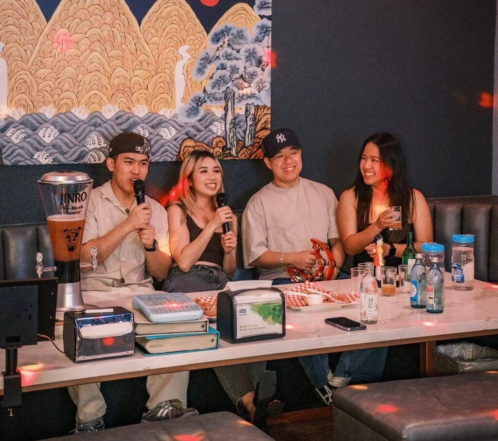 Four friends sit and sing karaoke at the Magpie and the Tiger