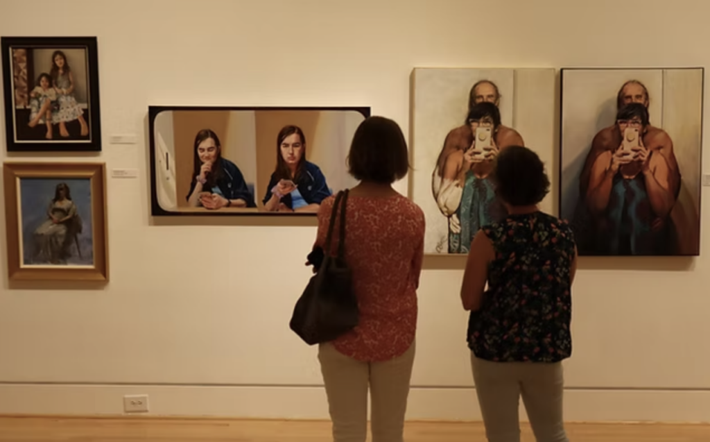 Two women look at paintings in the Triton Museum