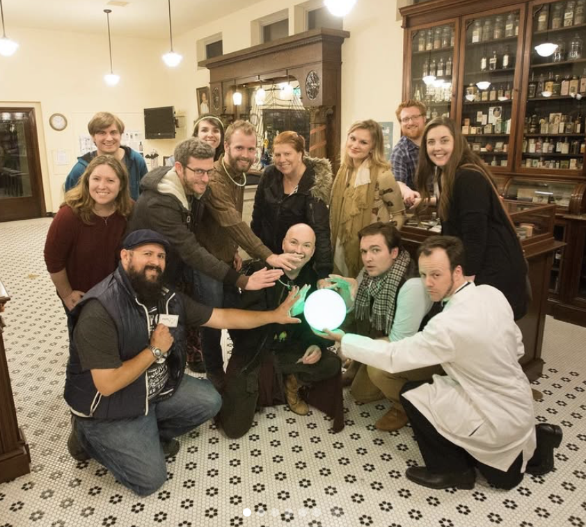 team members pose with a glowing orb after succeeding at Super Hero Academy