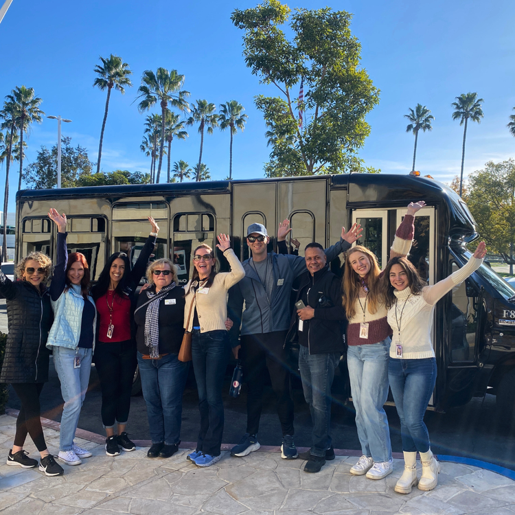 Team members pose in front of the Do Good Bus