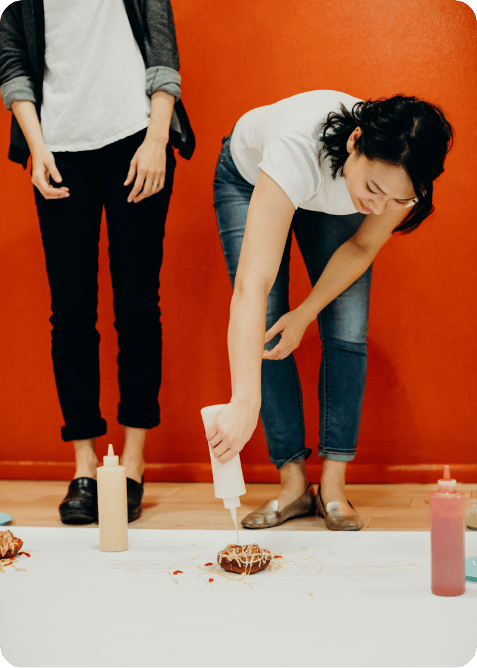 two guests adding frosting to donut during custom event with avital