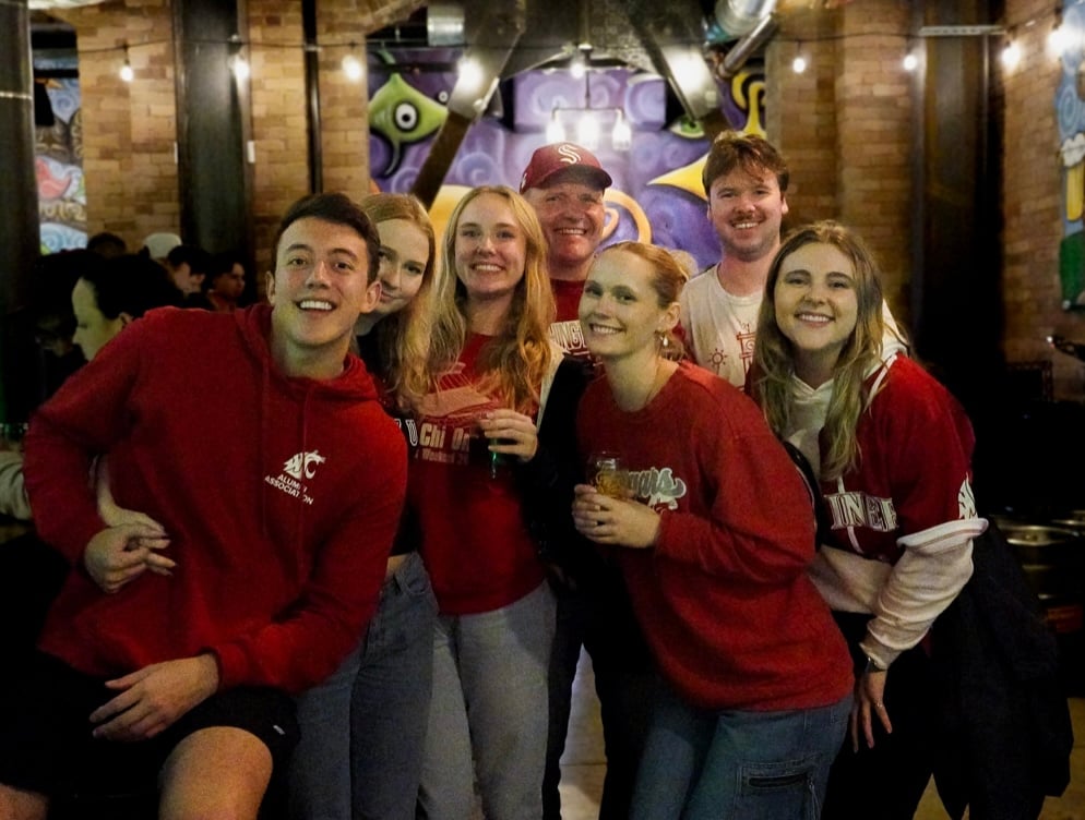 Coworkers pose in red and white clothing at Flatstick Pub