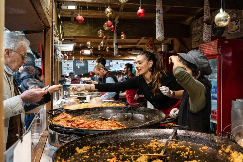 Food Festival workers hand out plates of steaming food to customers