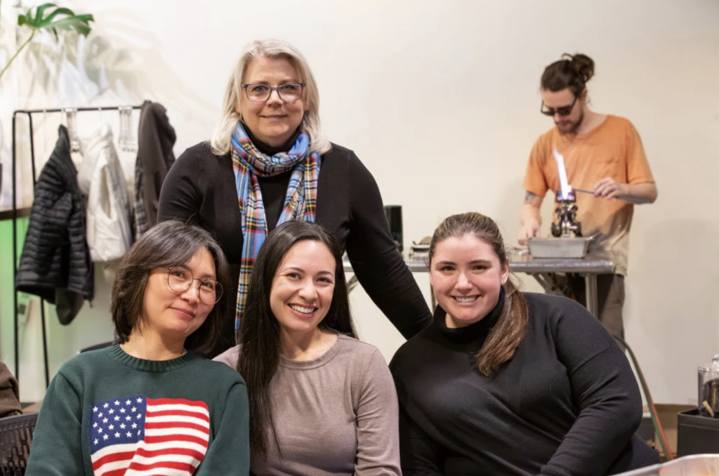Friends smile after making glass creations in a Seattle Gass Blowing Workshop