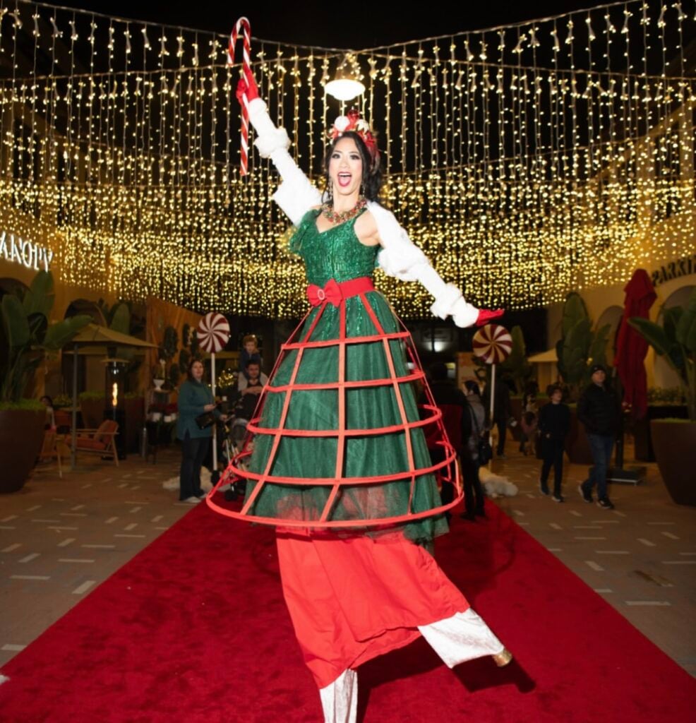 A eoman wearing festive clothes on a red carpet