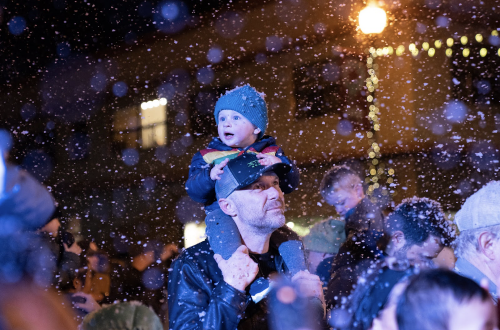 a baby on his dads back enjoys the snow