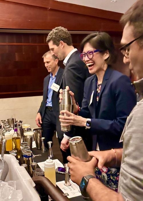 woman laughing as she makes a cocktail during chicago interactive mingling hour