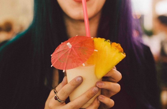 women drinking tropical drink during virtual bartender party
