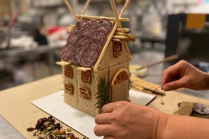 hands-making-a-charcuterie-chalet-with-orange-and-rosemary